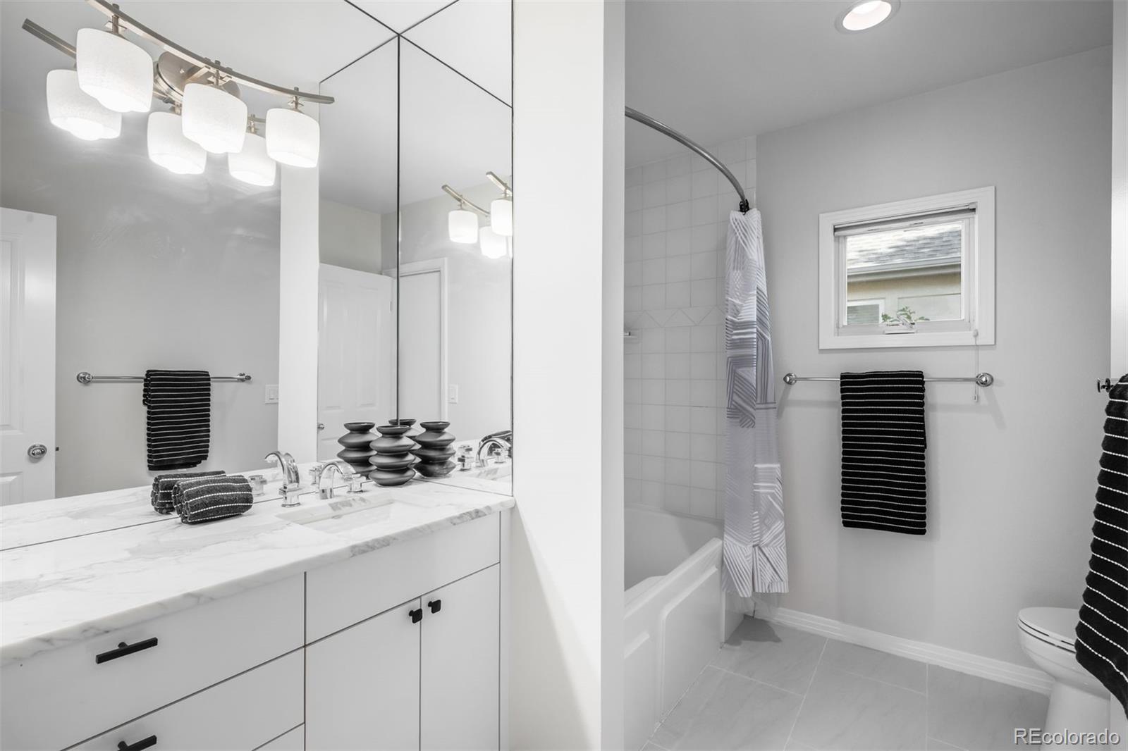 361 Detroit Street Denver, CO 80206 - Photo 29 of 46 a bathroom with a double vanity sink a toilet and shower