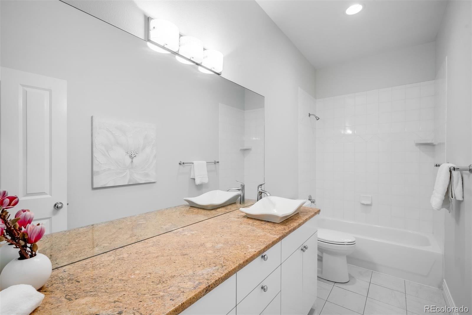 361 Detroit Street Denver, CO 80206 - Photo 39 of 46 a bathroom with a granite countertop sink a toilet and shower