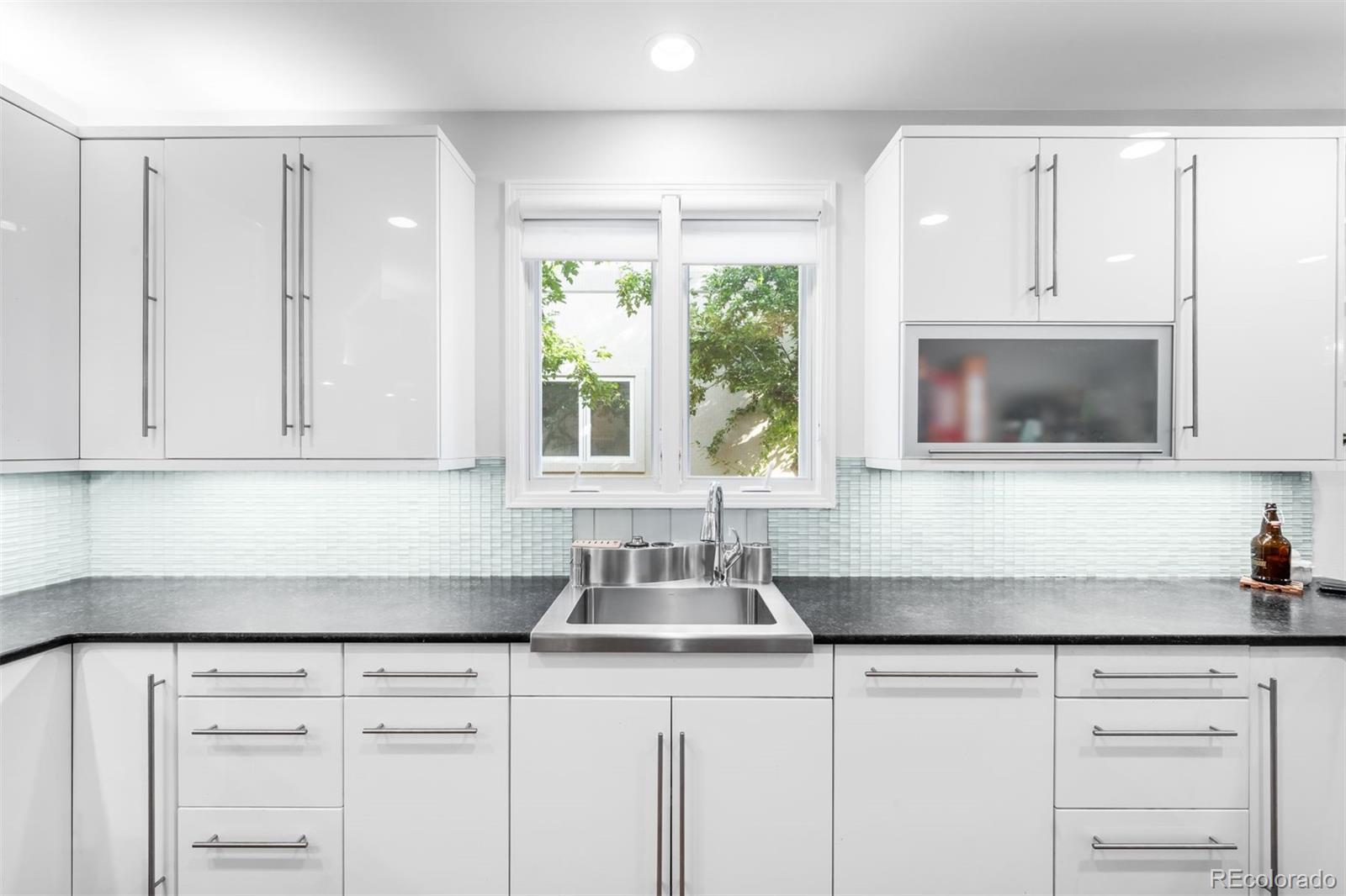 361 Detroit Street Denver, CO 80206 - Photo 9 of 46 a kitchen with white cabinets and a sink