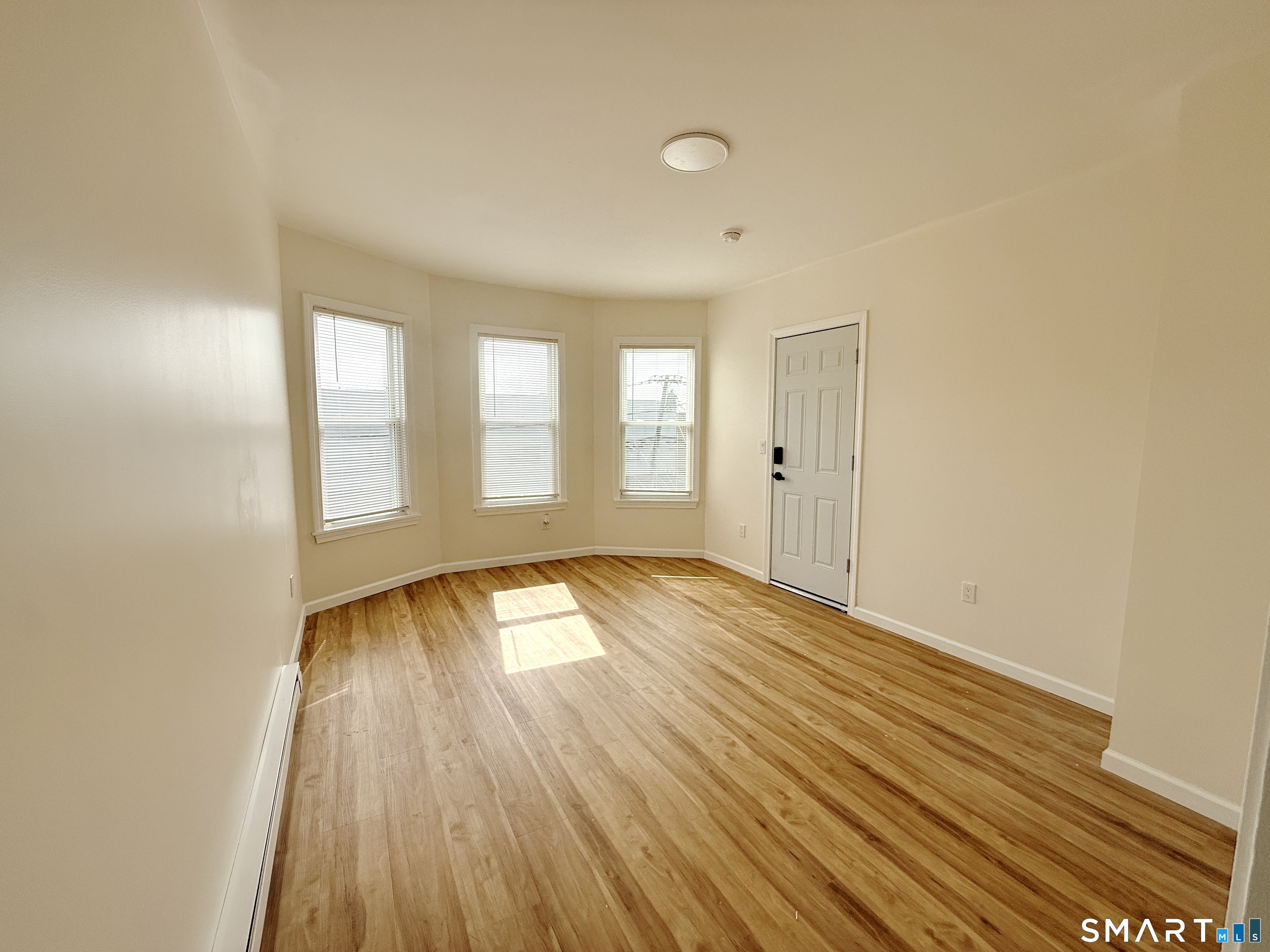 70 Lindley Street Bridgeport, CT 06604 - Photo 3 of 8 wooden floor in an empty room with a window