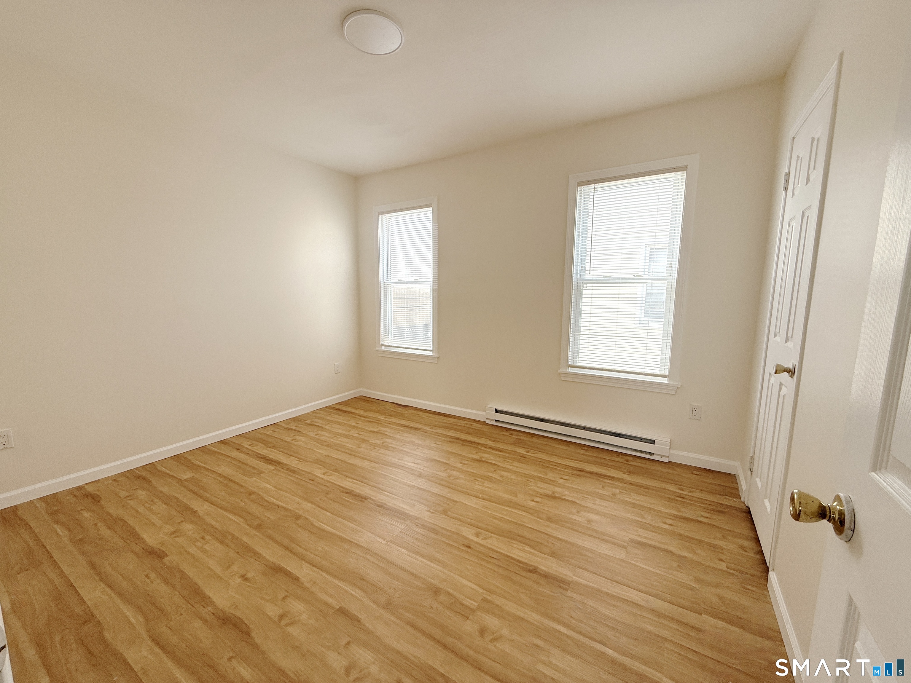 70 Lindley Street Bridgeport, CT 06604 - Photo 4 of 8 an empty room with wooden floor and windows