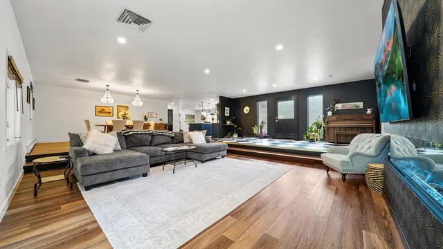 a living room with furniture and a wooden floor