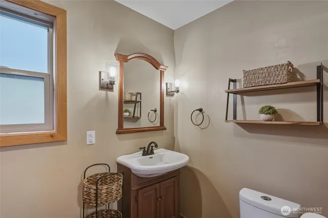 a bathroom with a sink a toilet and mirror