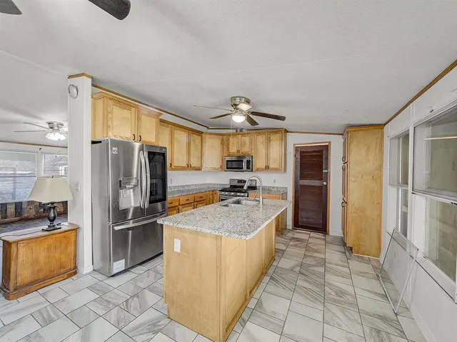 a kitchen with stainless steel appliances granite countertop a refrigerator a oven a sink with island and chairs
