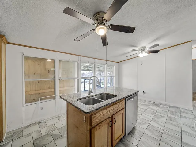 a kitchen with stainless steel appliances granite countertop a sink a stove cabinets counter space and a window
