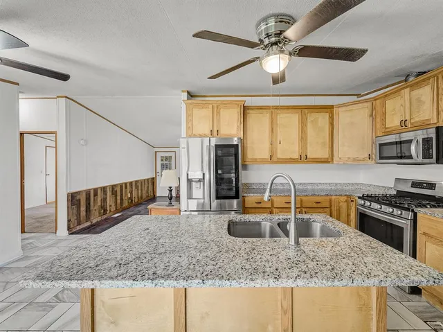 a kitchen with stainless steel appliances granite countertop a sink stove and cabinets