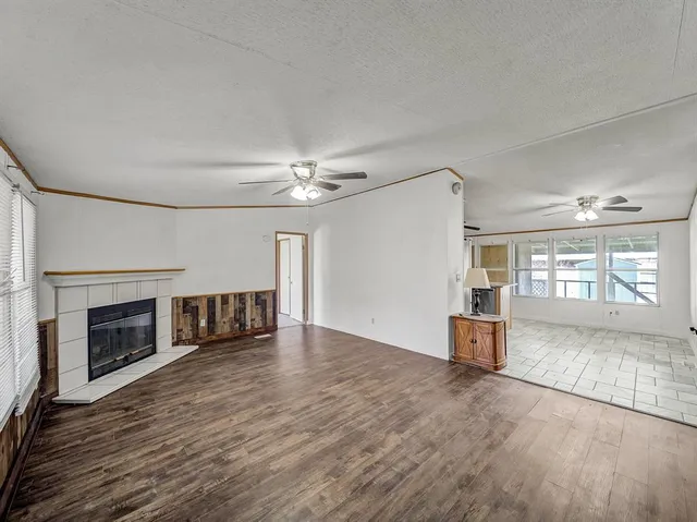 wooden floor fireplace and windows in an empty room