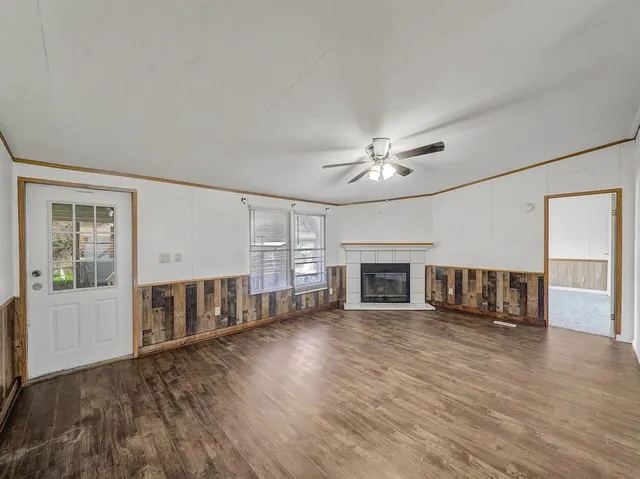 a view of a livingroom with a ceiling fan window and hardwood floor