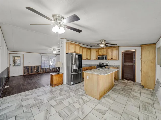 a kitchen with stainless steel appliances granite countertop a refrigerator and a sink