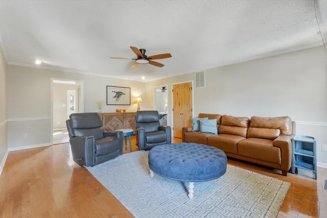 a living room with furniture kitchen view and a window