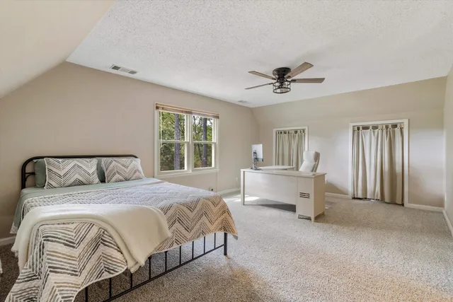 a spacious bedroom with a bed and a chandelier