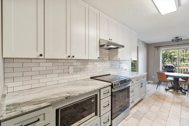 a kitchen with stainless steel appliances granite countertop a sink stove and cabinets