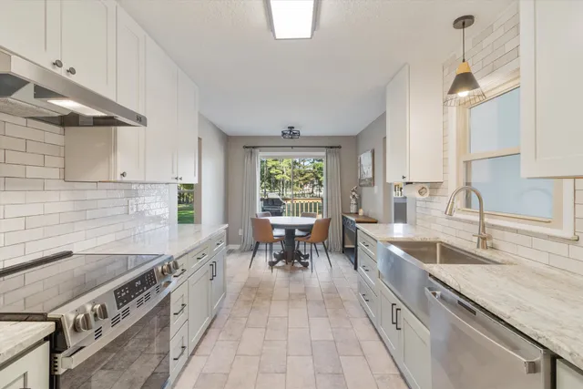 a large kitchen with stainless steel appliances granite countertop a lot of counter space and a sink