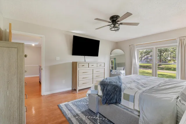 a living room with a bed furniture and a flat screen tv