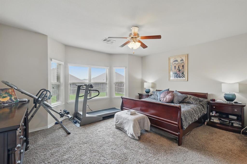 3013 Dominion Street Denton, TX 76209 - Photo 18 of 38 a spacious bedroom with a bed and a chandelier