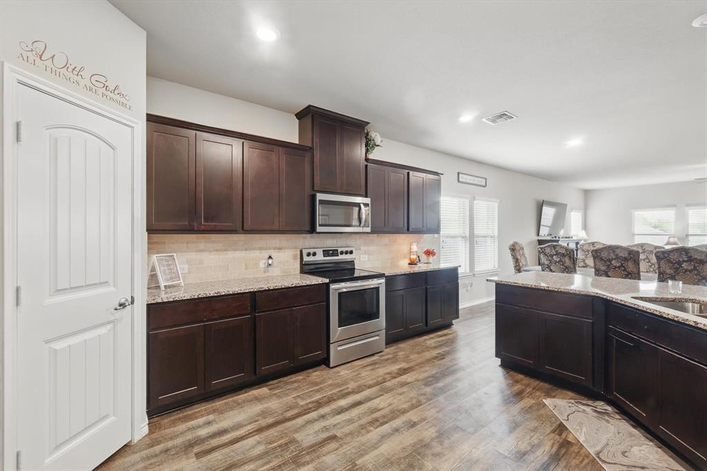 3013 Dominion Street Denton, TX 76209 - Photo 8 of 38 a kitchen with stainless steel appliances granite countertop a sink stove and refrigerator