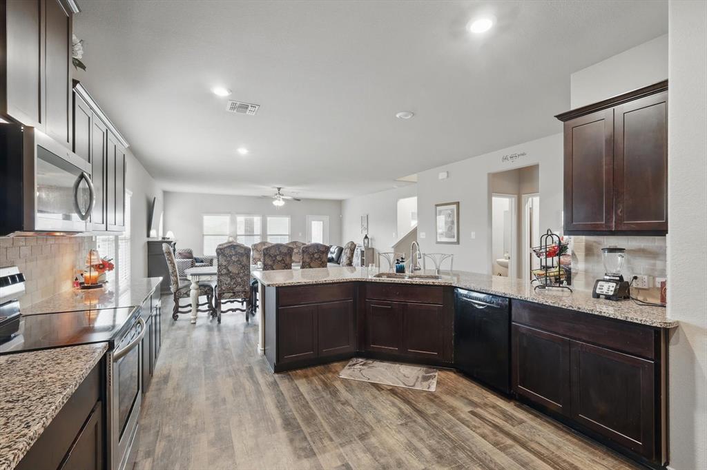 3013 Dominion Street Denton, TX 76209 - Photo 9 of 38 a kitchen with stainless steel appliances granite countertop sink stove top oven and cabinets
