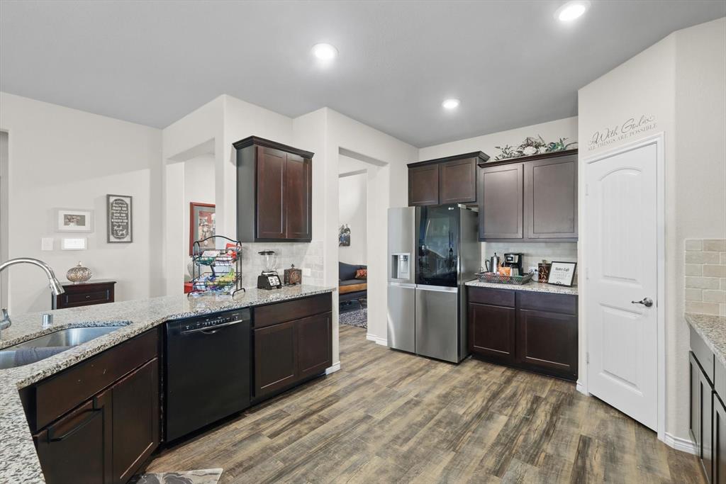 3013 Dominion Street Denton, TX 76209 - Photo 10 of 38 a kitchen with stainless steel appliances kitchen island granite countertop a refrigerator and a sink