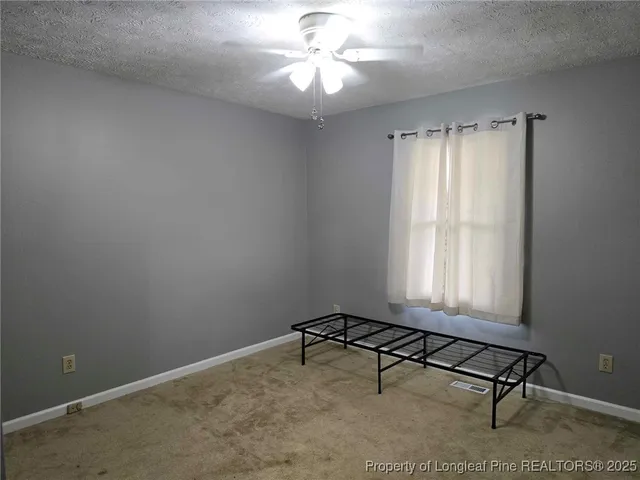 a room with chandelier fan and windows