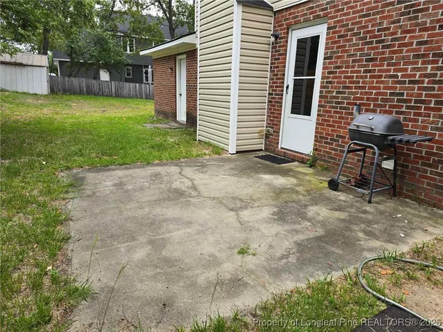 a view of backyard with large trees and wooden fence