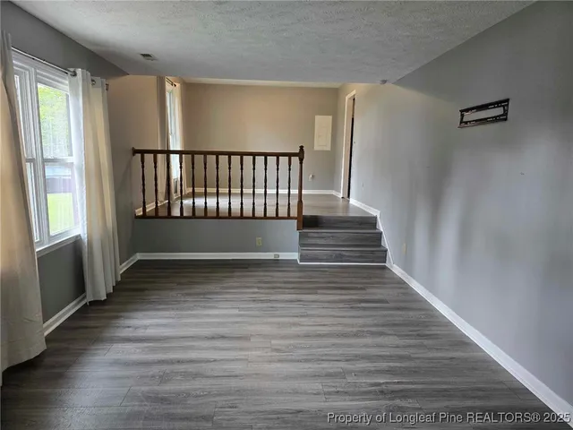 a view of a hallway with wooden floor and staircase