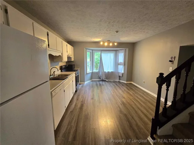 a view of a kitchen with wooden floor and electronic appliances