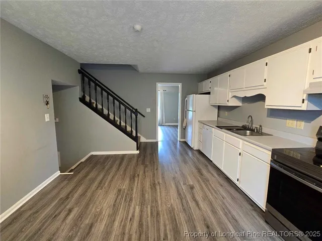 a kitchen with wooden floors and white appliances