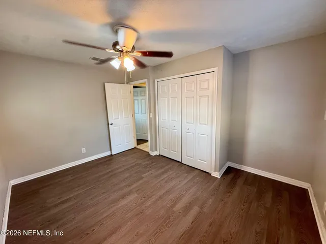 a view of an empty room with wooden floor
