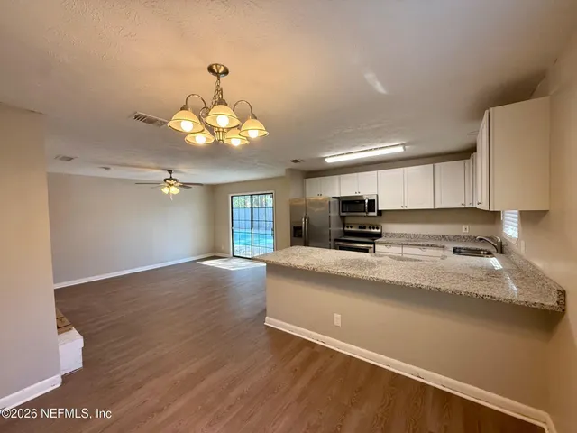 a view of a kitchen with a sink a kitchen counter top space and cabinets