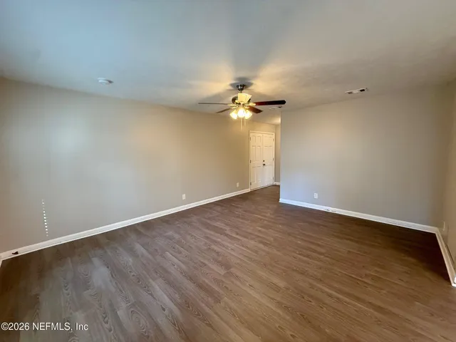 a view of an empty room with wooden floor