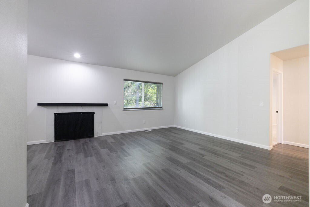 10720 Eustis Hunt Road East Graham, WA 98338 - Photo 4 of 27 an empty room with wooden floor and windows
