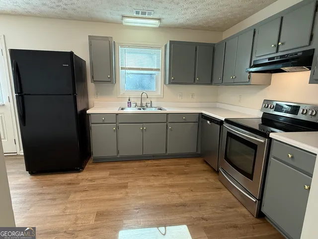a kitchen with a sink appliances and cabinets