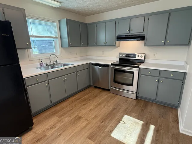 a kitchen with sink cabinets and stainless steel appliances