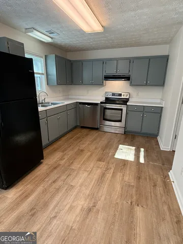 a kitchen with granite countertop stainless steel appliances and wooden cabinets