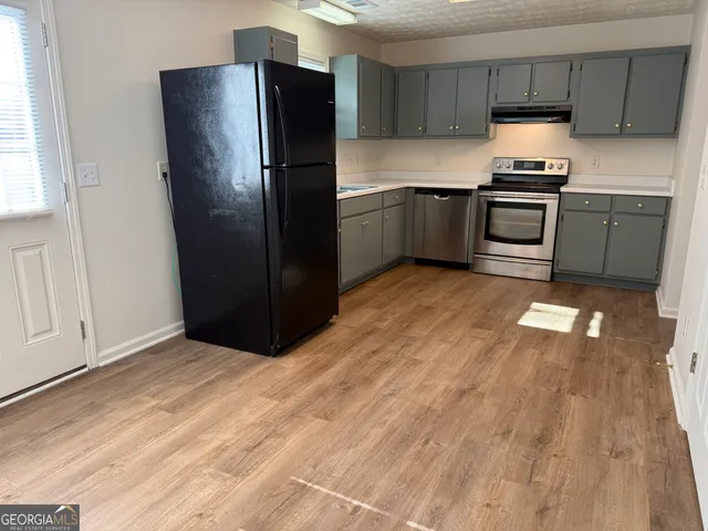 a view of an empty room and kitchen space