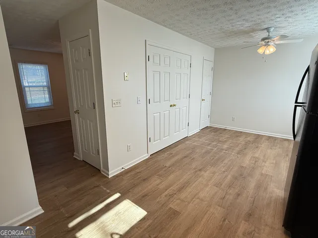 a view of an empty room with wooden floor