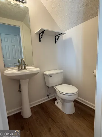 an empty room with wooden floor and door