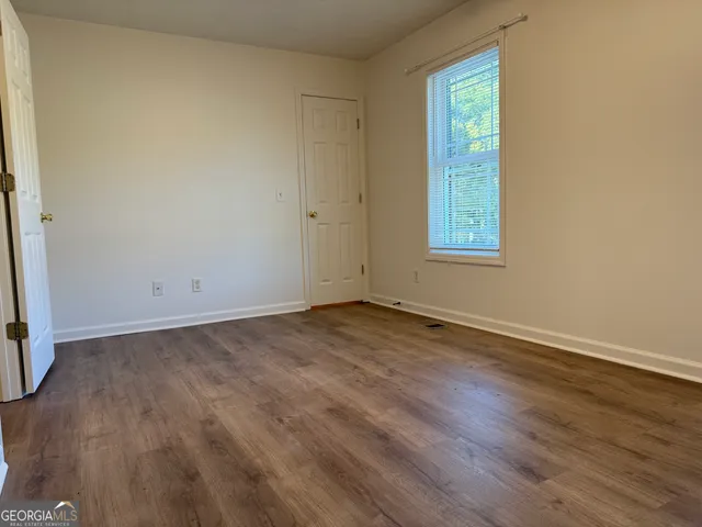 a view of an empty room with wooden floor