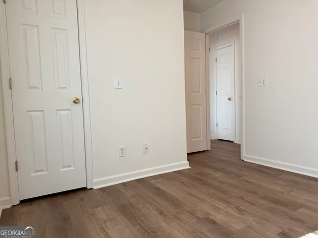 a view of a room that has wooden floor and cabinets