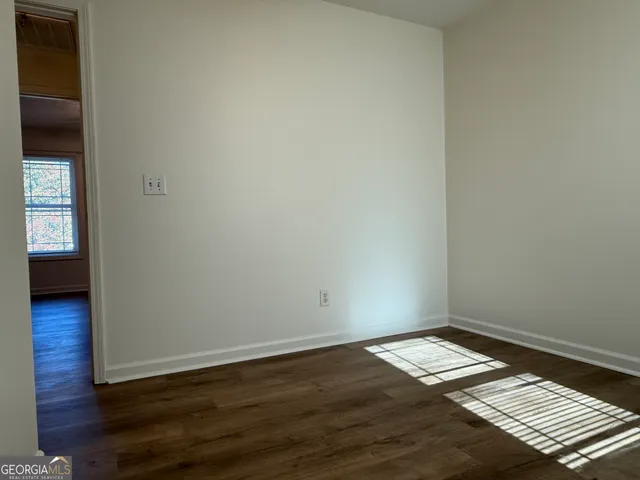 an empty room with wooden floor and a window