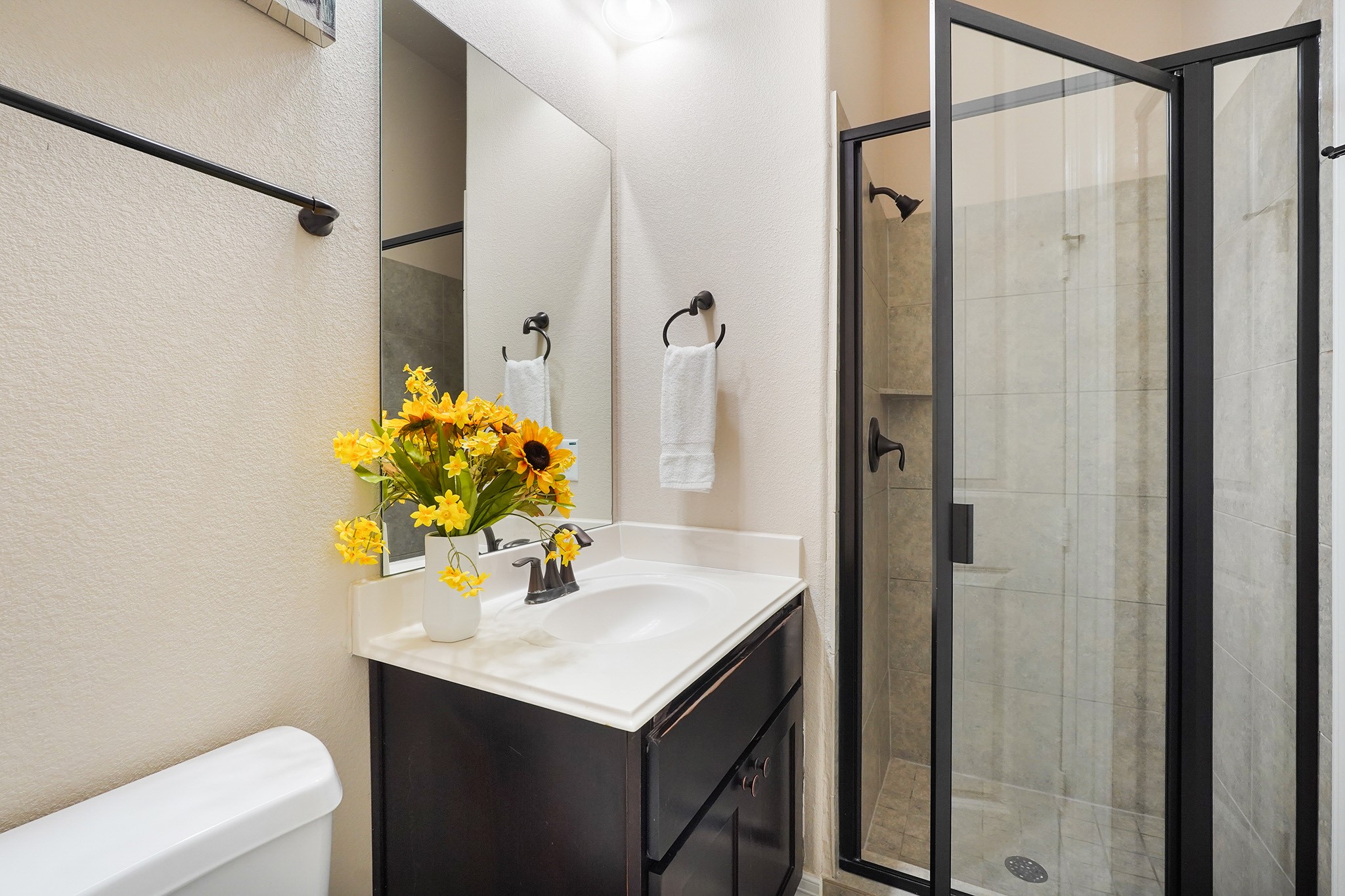 3102 Barrons Way Sugar Land, TX 77479 - Photo 18 of 42 FIRST Flr-2nd bedroom down: This bathroom features a modern glass-enclosed shower, and a sleek vanity with a white countertop. It has a neutral color palette and efficient use of space.