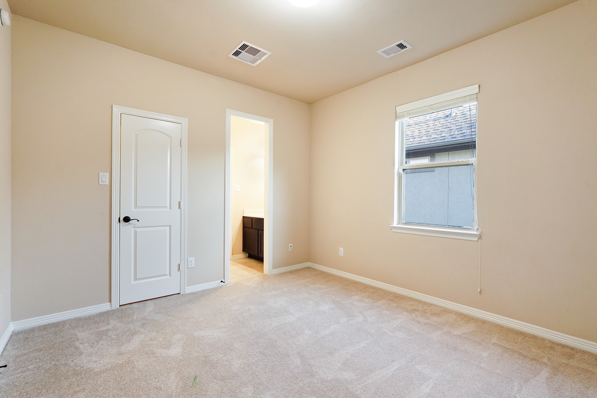 3102 Barrons Way Sugar Land, TX 77479 - Photo 30 of 42 SECOND Flr-Bed#5: This photo shows a cozy, carpeted bedroom with neutral walls, a window providing natural light, and a door leading to an adjacent bathroom.