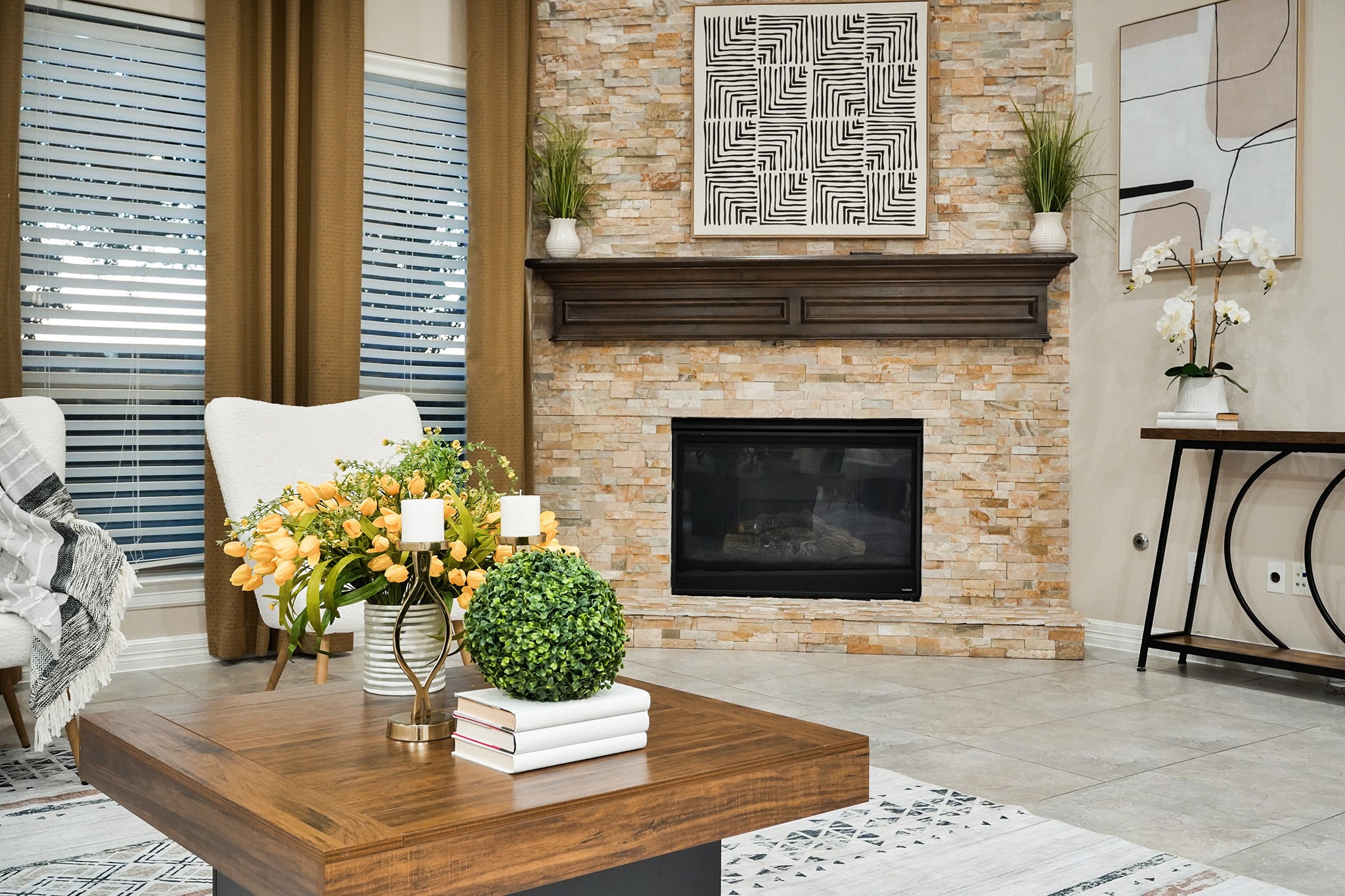 3102 Barrons Way Sugar Land, TX 77479 - Photo 9 of 42 This cozy living room features a stone fireplace with a dark wood mantel, complementing modern decor. Large windows with blinds and warm curtains provide ample natural light.