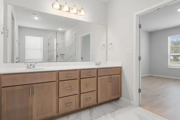 a bathroom with double sink and a mirror