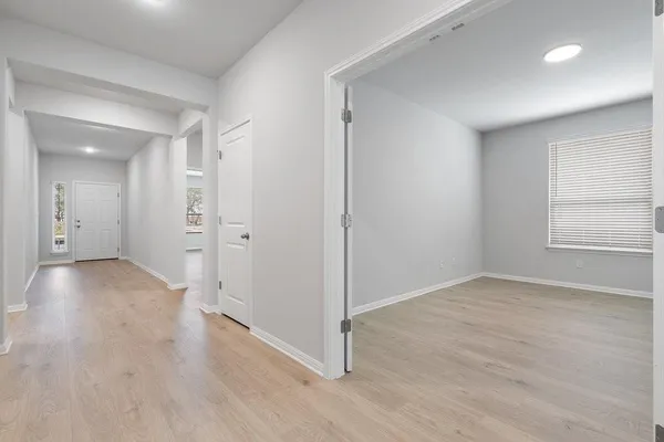 an empty room with wooden floor and windows