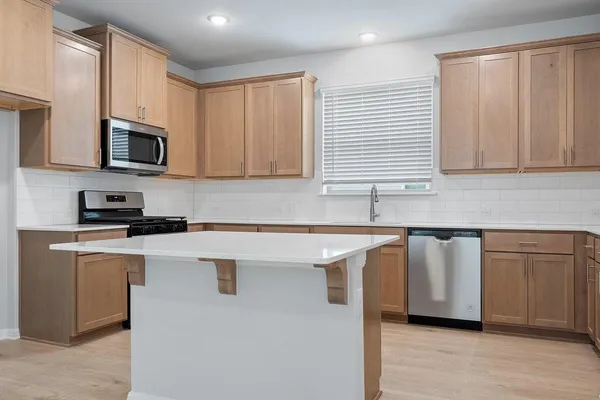 a kitchen with stainless steel appliances granite countertop a sink a stove and microwave
