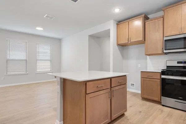 a kitchen with stainless steel appliances granite countertop a sink and a stove