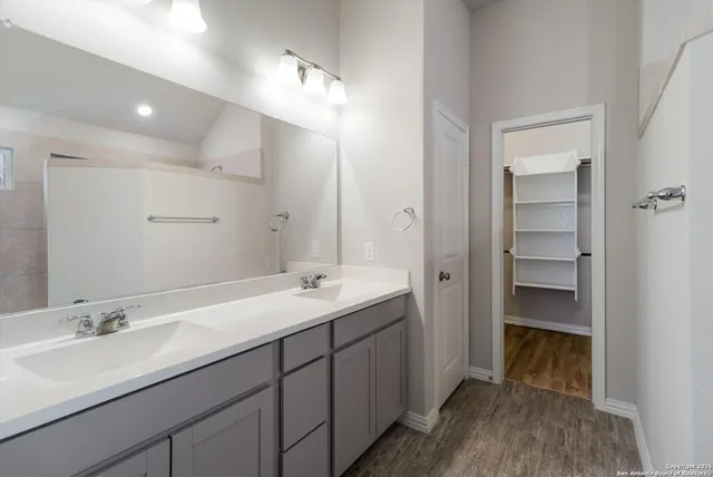 a bathroom with a double vanity sink and a mirror