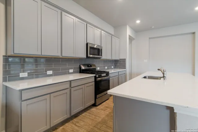 a kitchen with appliances a sink and cabinets