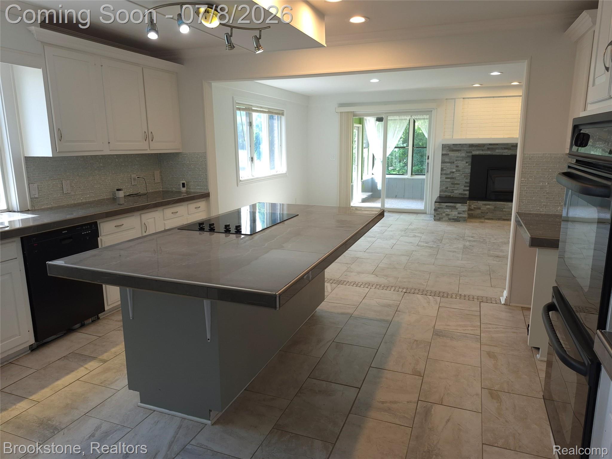 4140 South Henderson Road Davison, MI 48423 - Photo 20 of 98 Kitchen featuring an expansive center island with an integrated cooktop, white cabinetry, and gray countertops